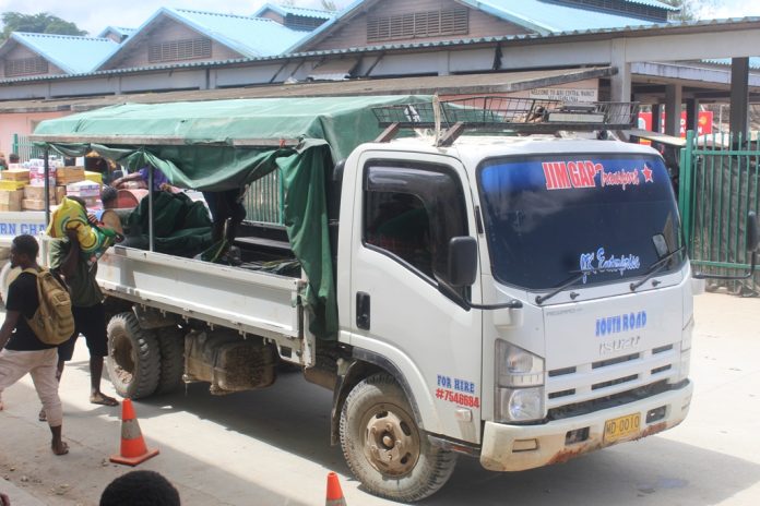 Passengers loading bag rice into a passenger truck from South Road yesterday in Auki.