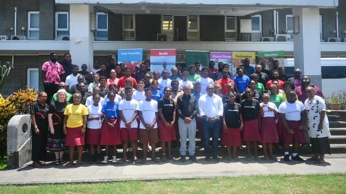 A group photo of students and members of parliament outside the Paul Tovua Complex building.