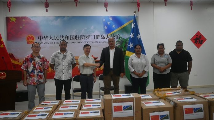(Third from left) Chinese Ambassador, Cai Weiming shakes hands with Hon John Tuhaika Jr infront of the donated materials.