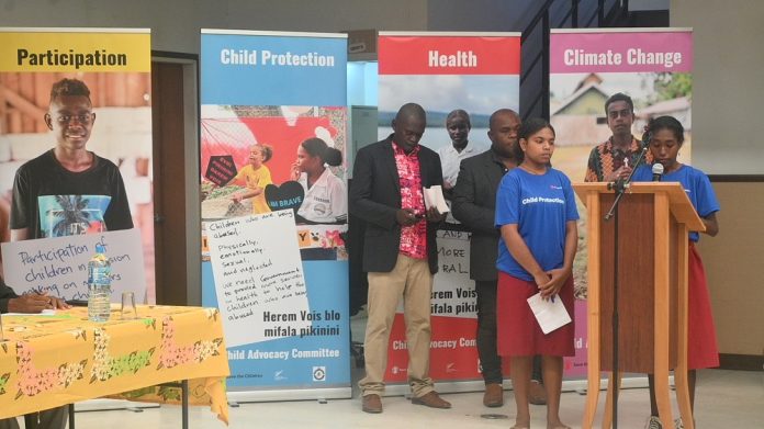 Two female students speaking about child protection at the event.