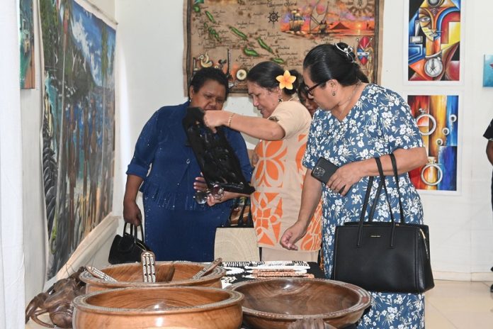 One of the PIF Leaders spouses examines a local piece as Madam Manele looks on.