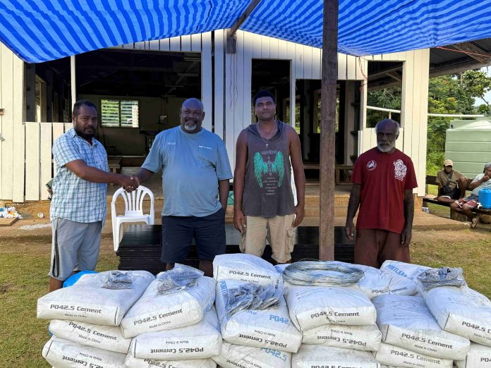 (Left to right) Vice Chair of Barana Catholic Church Fadius Bradly shake hands with MP Sade in receiving the materials. Picture by Ned Gagahe.