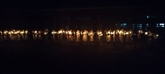MBH Mission team holding candles while walking to the centre of the court