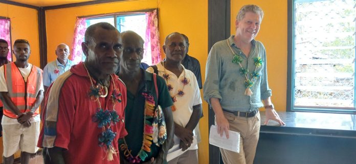 Mr Turner pose for a photo with leaders of Pusiju community in the Fishery Centre