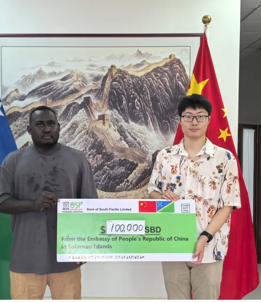 A rep from constituency office received the cheque from Chinese Embassy official. Photo credit Shortland Constituency office