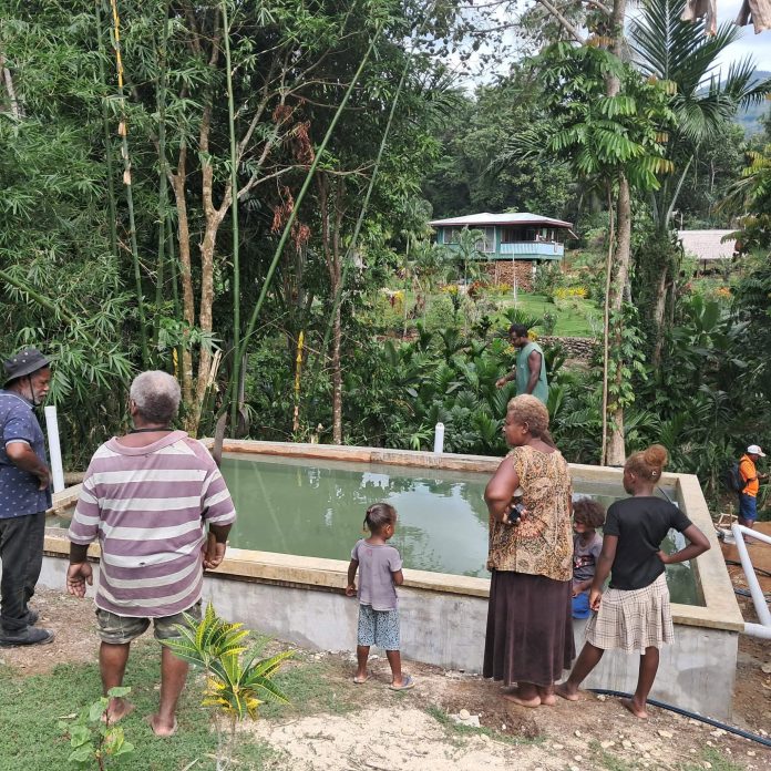 Kwene villagers gather around their newly stocked Mozambique tilapia pond, Photo credit- Mathew Isihanua