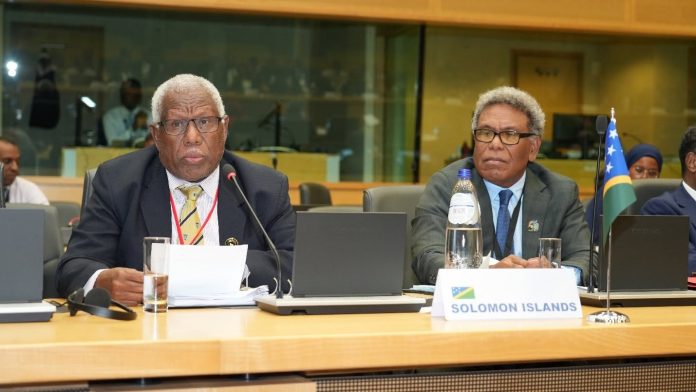Minister Houenipwela (left) with a Solomon Islands delegation member during the 121st Ordinary Session of the OACPS Council of Ministers Meeting in Brussels. Photo credit -MFAET